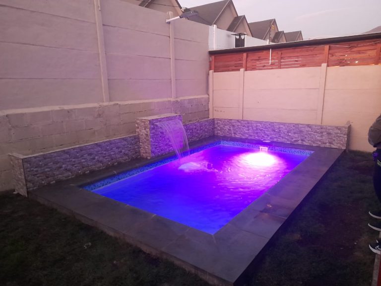 Piscina residencial con iluminación LED y cascada